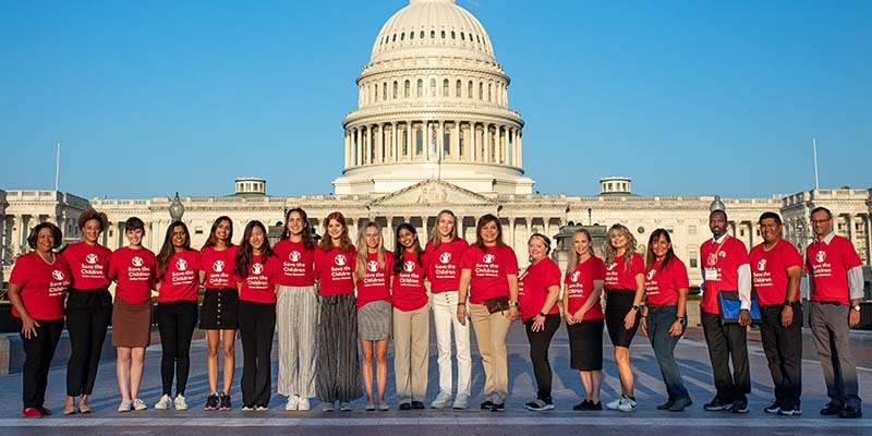 In Washington D.C., a group of student advocates wear Save the Children Action Network shirts and stand in front of the U.S. Capitol Building. 